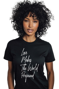 Person wearing a black t-shirt with 'Love Makes The World Profound' text on a plain background